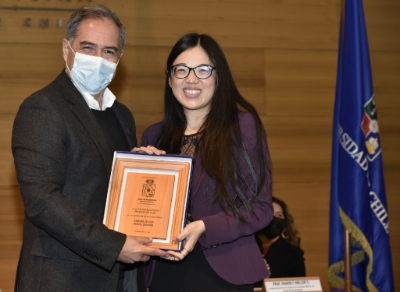 La tecnóloga médica Cindia Tong recibe su distinción como Mejor Rendimiento Académico 2019 de manos del decano de la Facultad de Medicina, doctor Miguel O'Ryan.